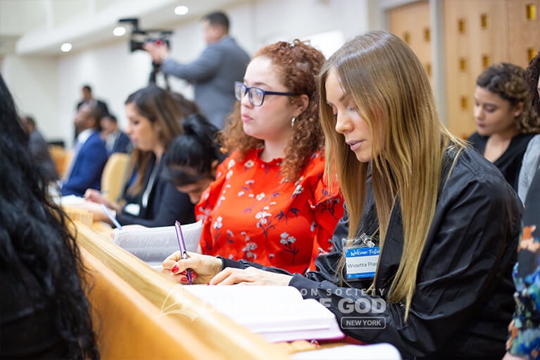 New members taking notes during the group Bible study.